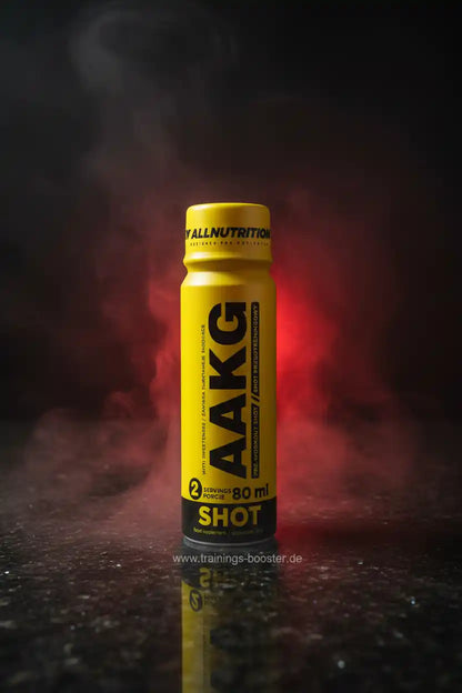 AAKG Shot - Energiebooster für Training mit 80 ml, gelbe Dose vor rotem Rauchhintergrund