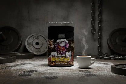 BPS Pharma WheyChino Proteinpulver in Caramel Macchiato neben einer Tasse Kaffee im Fitnessstudio.