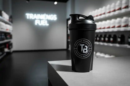 Schwarzer Shaker mit TB-Logo vor einem Fitnessstudio-Hintergrund