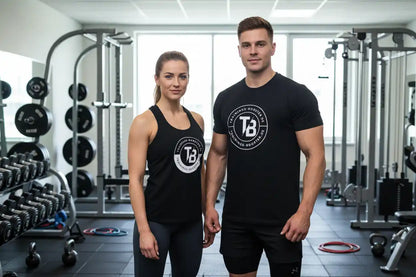 Fitnesstrainer in Sportbekleidung im Fitnessstudio mit Hanteln und Trainingsgeräten.