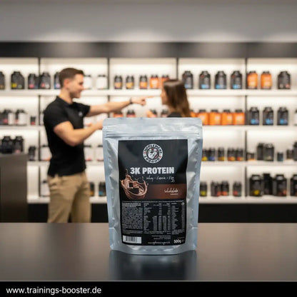 Supplement Support 3K Protein 500g Schokolade Beutel vor unscharfem Fitness-Shop Hintergrund